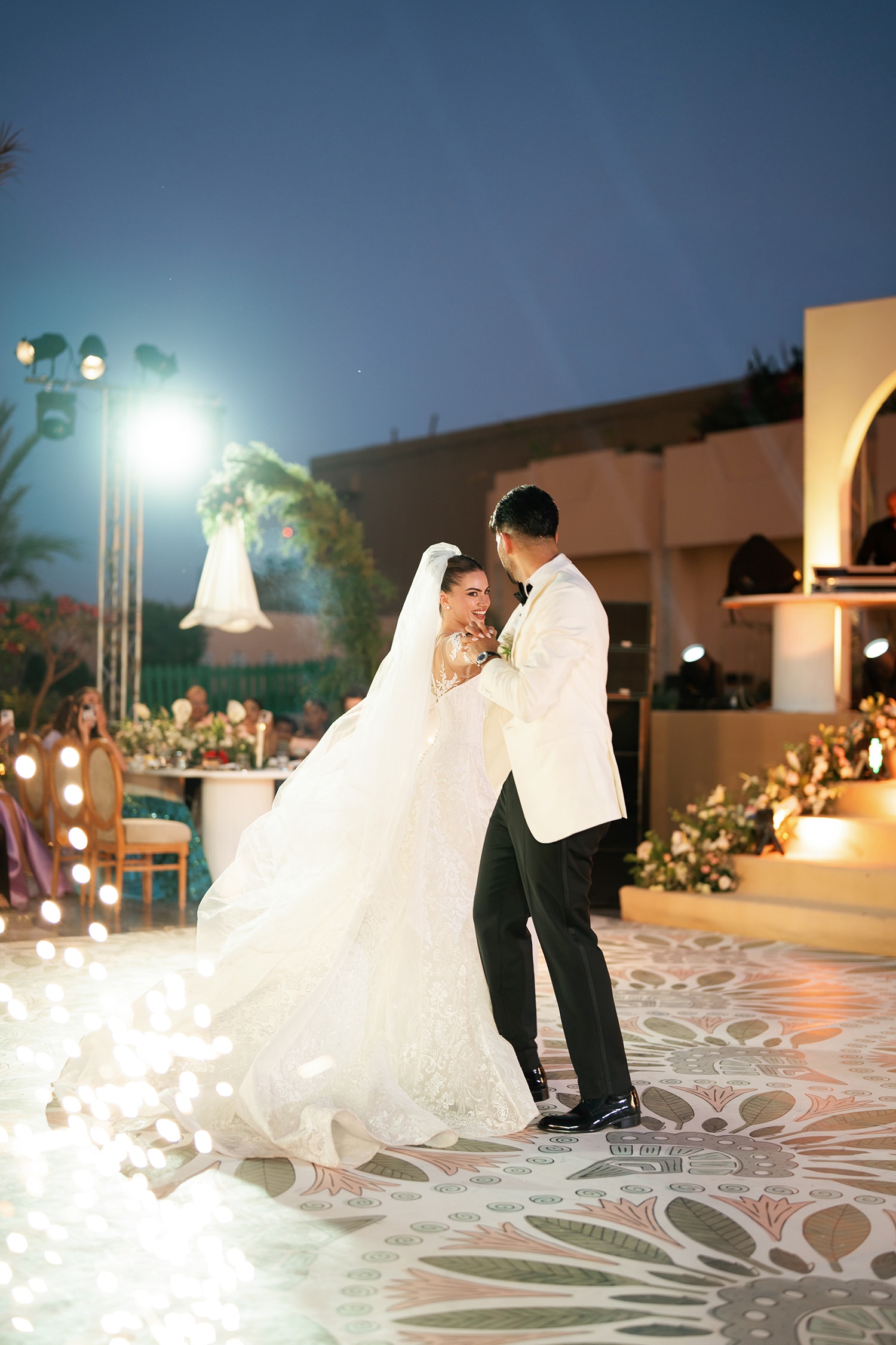 Groom lifting bride elegant evening wedding reception